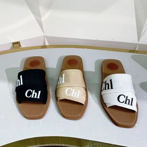 2024 Yeni Tasarımcı tıkanma terlikleri slayt yaz seyahat sandale bayan hediye odunsu düz sandal kaydırıcılar bayan otel tuval gündelik ayakkabı aşındırıcı erkek lüks lüks siyah beyaz katırlar