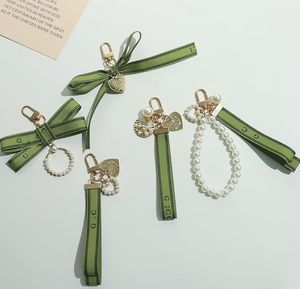 Designer Keychain Luxury Key Chain Bag charme fêmea carm feminino anel de pérola charme verde fita delicada casca de chave de chave de chave de pendente por atacado