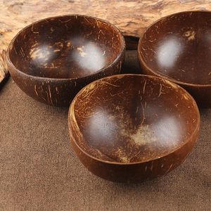 Миски кокосовая чаша натуральная деревянная посуда на фоне ложек десерта салат из рисовых оболочек установленные ремесла ручной работы ручной работы