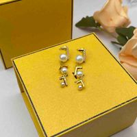 Pendientes de moda para mujeres Joyas de diseñador Diseñadores de pendientes para mujer F Notas de oro con orejas de perlas Accesorios de moda de la calle 2303106F