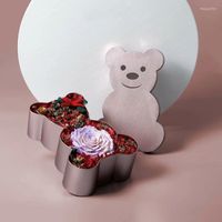Scatola di cartone a forma di orso regalo con regali di fiorista sul coperchio che confezionano fiori di decorazione per la casa fulcro del centrotavola