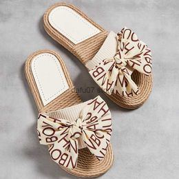 Slippers One line womens slippers made of hemp rope and grass summer new outdoor letter bow worn on the outside with a flat heel coverH240306