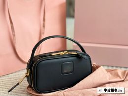 The small camera bag can be carried by hand or crossbody