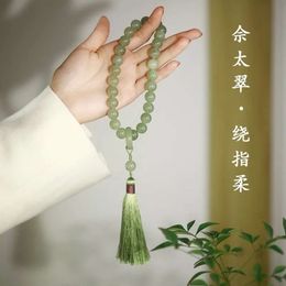 Qingqing Zijin cultural playful bracelet, wrapped around her fingers in a gentle ancient style. She holds eighteen seed prayer beads, bracelets, and Hanfu