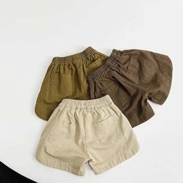 Shorts 2024 Summer New Boys and Girls Vintage Solid Beach Shorts Childrens Loose Casual Shorts Childrens Cotton Middle Trous Preschool Clothing d240510