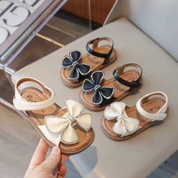 Sandaler Girls Sandaler 2024 Summer Childrens Princess Flat Sandals Fashion New Sweet Bow Knot Childrens Shoulder Beach Shoes Open Toe Soft Solel240510