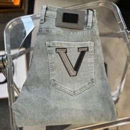 Lyxiga kvinnodesigner jeans ihopkopplade med ultravisk bomullstvättad denim präglade höga elastiska byxor