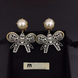 2024 Designer Mui Mui Jewelry Family Miao Familys New Gold Bowknot Pearl Earrings French Light Luxury Exaggerated Temperament Fairy Silver Needle