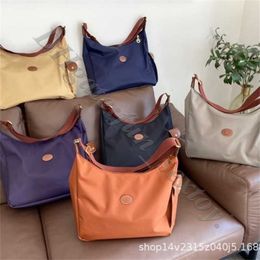 Folga de bolsas de varejo por atacado de 95% fora de sacos designer feminino bolsa de bolsa 2024 o passageiro pode ser o mesmo crossbody de grande estilo de nylon faye um ombro postman