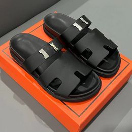 Дизайнерские тапочки с тапочкой мужские скользкие женские сандалии металлические буквы скольжения высококачественные обувь на открытом воздухе пара моды.