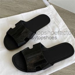 The Row leather TR slippers eel with round toe and exposed toe with a gold flat bottom and smoke rubber bottom worn on beach for womens sandals