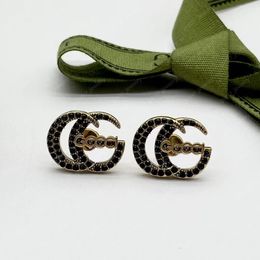 Fashionable and charming black stone bronze g designer earrings. High-end jewelry for Christmas and Valentine's Day gifts.