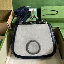 Designer Medium bag geometrically shaped with one studded handle one canvas strap and a leather strap top quality crossbody bag