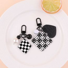 Keychains Creative leather plaid acrylic with black and white plain grain keychain pearl bell fashionable headphone case charm G230526