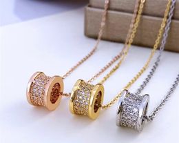 Designer, classic diamond-encrusted cylinder gold, silver and rose gold pendant, clavicle necklace.
