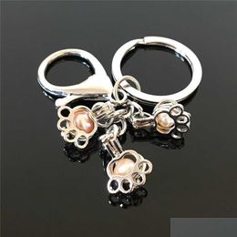 Keychains Lanyards Euro-American Paw Print Pearl Cage Key Ring Can Open Hollow Noctilucent Volcanic Stone Pendant Keyring Drop Deliv Dhtiz