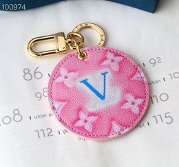 Pink round gold keychain with blue lettering is a fun hanging accessory