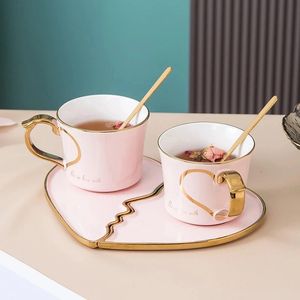 A pair of heart-shaped coffee cups with sauce and spoon on the golden ring creative tea cup set ceramic tableware luxurious wedding couple gift 240125