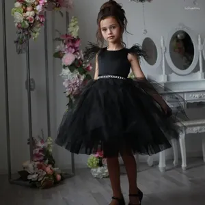 Abiti da ragazza in tulle nero con soffici piume che bordano l'abito a fiori senza maniche al ginocchio per l'abito da ballo della prima comunione dei bambini della principessa di nozze