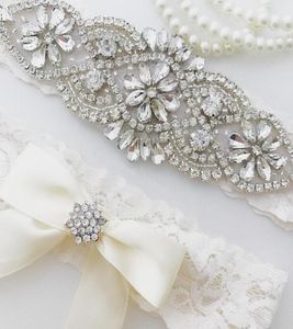 Bröllop Bridal Garter Set Crystal Rhine på en vit spetskristallkastning med elfenben Bow7331307