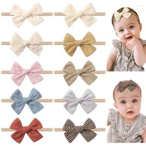 ヘアアクセサリー10pcs/set lace print bows baby headband弾性ナイロンバンド生まれplaid花ソリッドヘアバンドの幼い少女