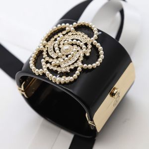 Moda europea e americana, design esagerato e suggestivo, bracciale da donna con fibbia aperta in acrilico con perle di diamanti e acqua di camelia nera di alta qualità