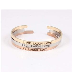 Inspirierendes Armband mit Edelstahlmanschetten und Gravur „LIVE LAUGH LOVE“.