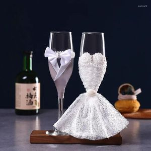 ワイングラスの絶妙な結婚式のマッチメイキングセレブレーションロマンチックなシャンパン花groom花嫁の茎の手を渡す