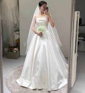 上品な長いストラップレス韓国のウェディングドレスA-Line Ivory Satin Speak Train Lace Up Back Simple Bridal Gowns with Pocket