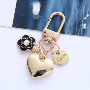 Designer nyckelkedjan plånbok nyckelringar för kvinnor hjärta lyxiga nyckelning kamellia sinensis nyckelring tillbehör armbands varumärken