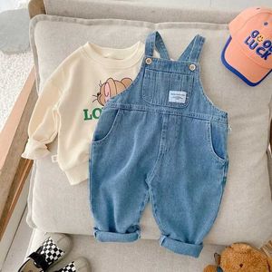 Overalls New Autumn Childrens denim jumpsuit for young children boys and girls loose hanging pockets long pants jeans fashionable jacket for 1-7 years d240515