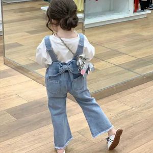 Overall 2023 Autumn New Girl Overalls Childrens Trousers Baby Girl Back Bow denim Överallt Barn Elastiska jeans babykläder D240515