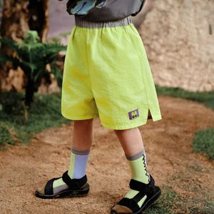 Shorts Amila 2024 Sommar Nya barns bottenflicka ren färgade shorts för avslappnad sportstil kan bäras på båda sidor av byxorna D240516