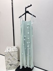 ファッションデザイナーが最新の夏休みコレクションの長いプリーツドレスをデザインします