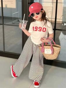Zestawy odzieży Zestawy odzieży Nowa dziewczyna Zestaw z krótkim rękawem Summer Childrens T-shirt Zestaw odzieży Nieregularny top+spodnie w paski 2PCS Dziecięce Zestaw mody 2-8Y WX5.23