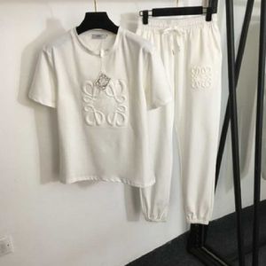 ブランドデザイナートラックスーツの女性2ピースセットサマーコットンホワイト刺繍幾何学的な短袖Tシャツドローストリングエラスティックウェイストとフットチンシングのカジュアルパンツセット