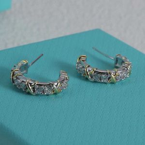 Modemärke guldplätering med hög upplaga korsfärgade örhängen med vit diamant för avancerad ljus lyxdesign