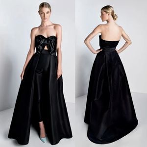 Billiga svarta jumpsuits promklänningar med löstagbar tåg båge stropplös halsformell aftonklänningar satin overskirt prom klänning