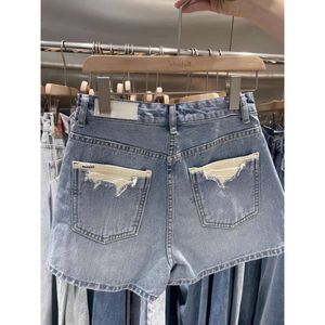 Niebieskie dżinsowe spodenki dla kobiet lato 2024 Nowy luźny i odchudzający wszechstronny design z patchworkowym A-line szeroko zakrojone spodnie