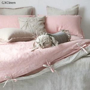 A cama define a tampa de edredon de linho de dois lados e a fronha em cor natural rosa claro com fechamento de gravata dormindo linho nu personalizado