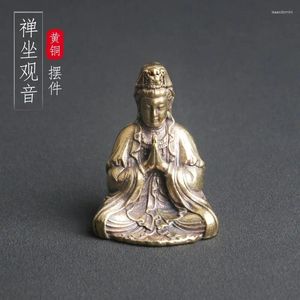 Halsband örhängen som sitter i meditation mässing Buddha -statyn av Guanyin bodhisattva från Sydkinesiska havet är förankrad bordsskiva som en