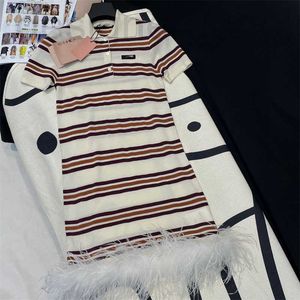 Grundläggande klänningar Designer 24 Tidig vår Ny Nanyou Miu Fashion Age Minskar kontrast Stripe skarvad fjäderpolo hals stickad kortärmad klänning NHMI