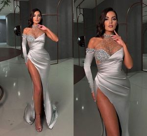 2024 Sexy High Thigh Split Evening Dresses Wear Sheer Halter High Neck Mermaid Long Sleeves Silver Satin Sheath Crystal Beads Lace Appliques Formal Prom Dresses