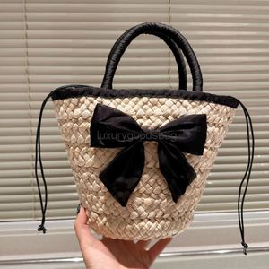 2024SS 세련된 Bowknot Bucket Beach Bag 여성 중공 아웃 크로 셰 뜨개질 토트 수제 밀짚 짠 야채 바구니 여름 방학 가방 드로 스트링 작은 가방