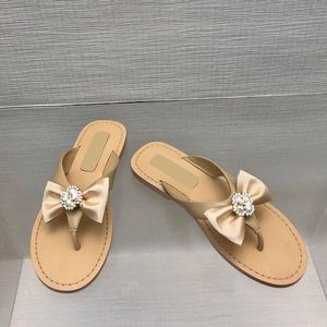 Luxurys kvinnors glid på tofflor fårskinn thong sandaler designer flip-flops med bowtie pärla quiltade textur glider damer mulor utomhus strandsko med dammpåsar