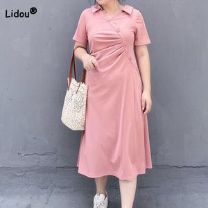 プラスサイズのドレス韓国のサイズの女性の服ソリッドカラープリーツの斜めのバックル短袖ルーズアラインミディドレス230905の非対称デザイン