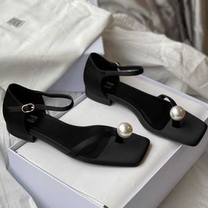 Scarpe da designer toteme scarpe sandali le donne piatti perle neri piatto accentuati con un'elegante perle finta sul sematelo in piedi e una cinturino della caviglia in pelle