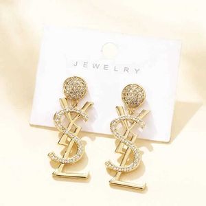 S925 Silver Needle Copper Micro Inlaid Letter Earrings New Fashion Round Face Slim and Long örhängen för kvinnor