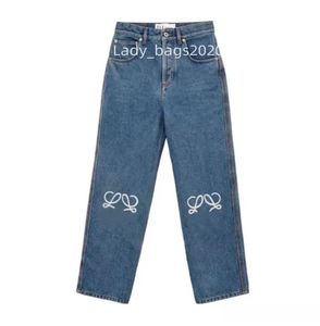 Designer kvinnor jeans ankomster lyxiga blå jean byxor ben öppen gaffel tät hög midje gata ihålig lapp broderad dekoration casual rak denim byxor