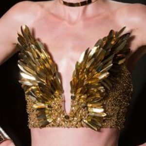 Una bellissima modella che indossava un abito da sera dorato decorato con piume con paillettes apparve all'ultimo lancio di Zuhair Murad Brand nel 2023.